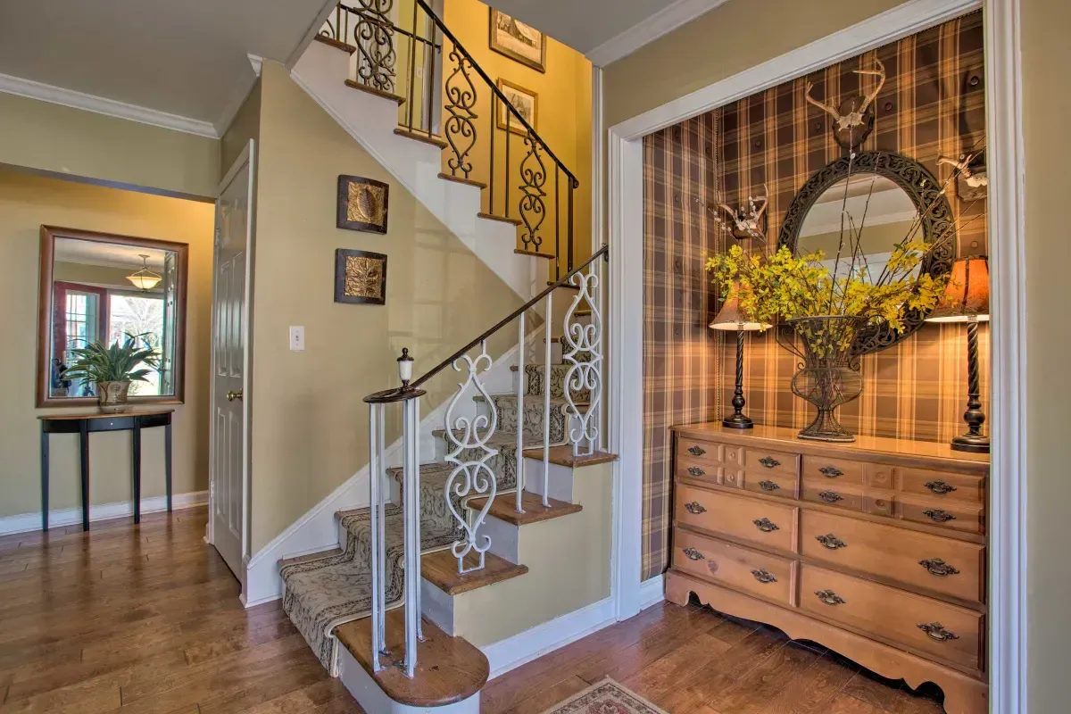 a hallway with a staircase and a dresser