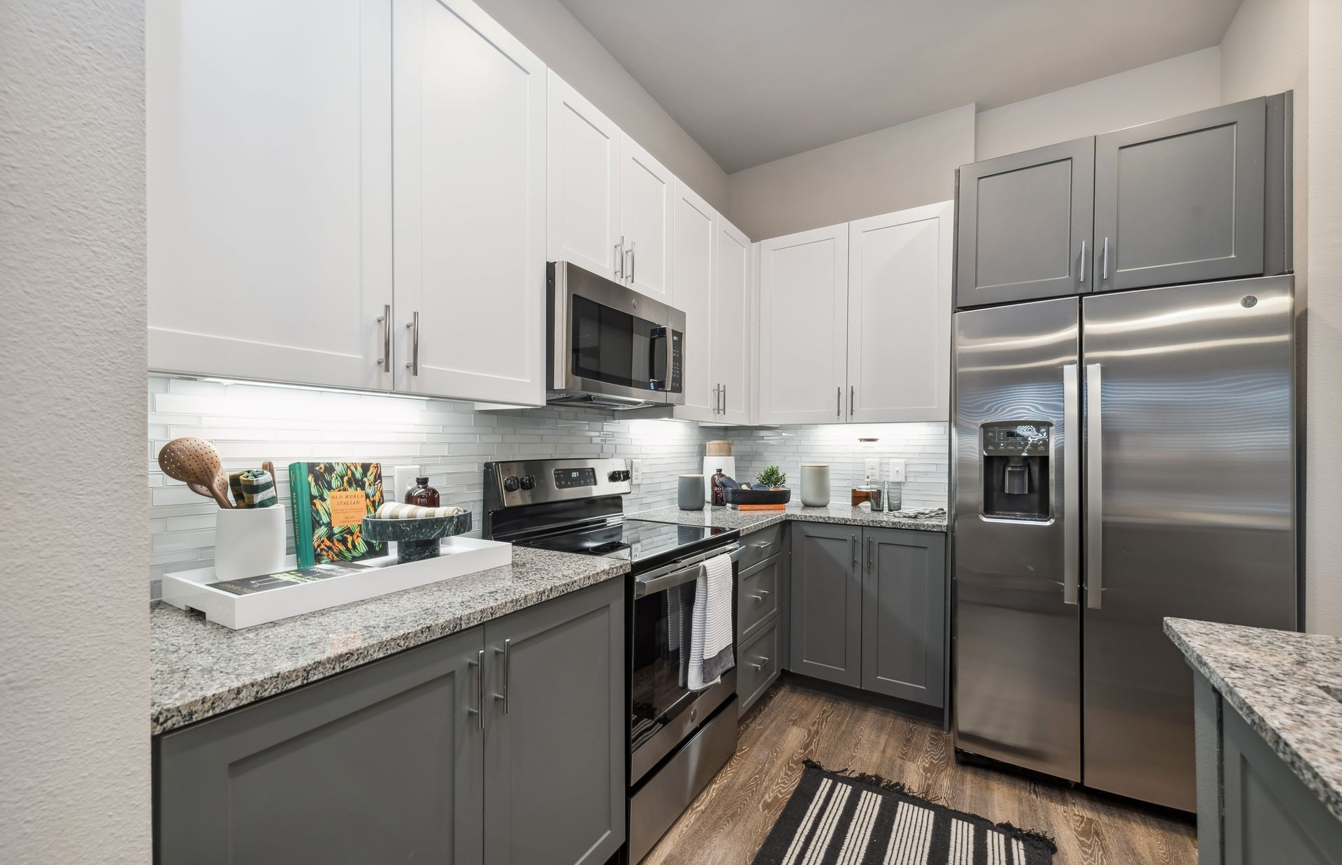 Modern kitchen with white cabinetry and stainless-steel appliances at One90 Gateway in Plano, TX.