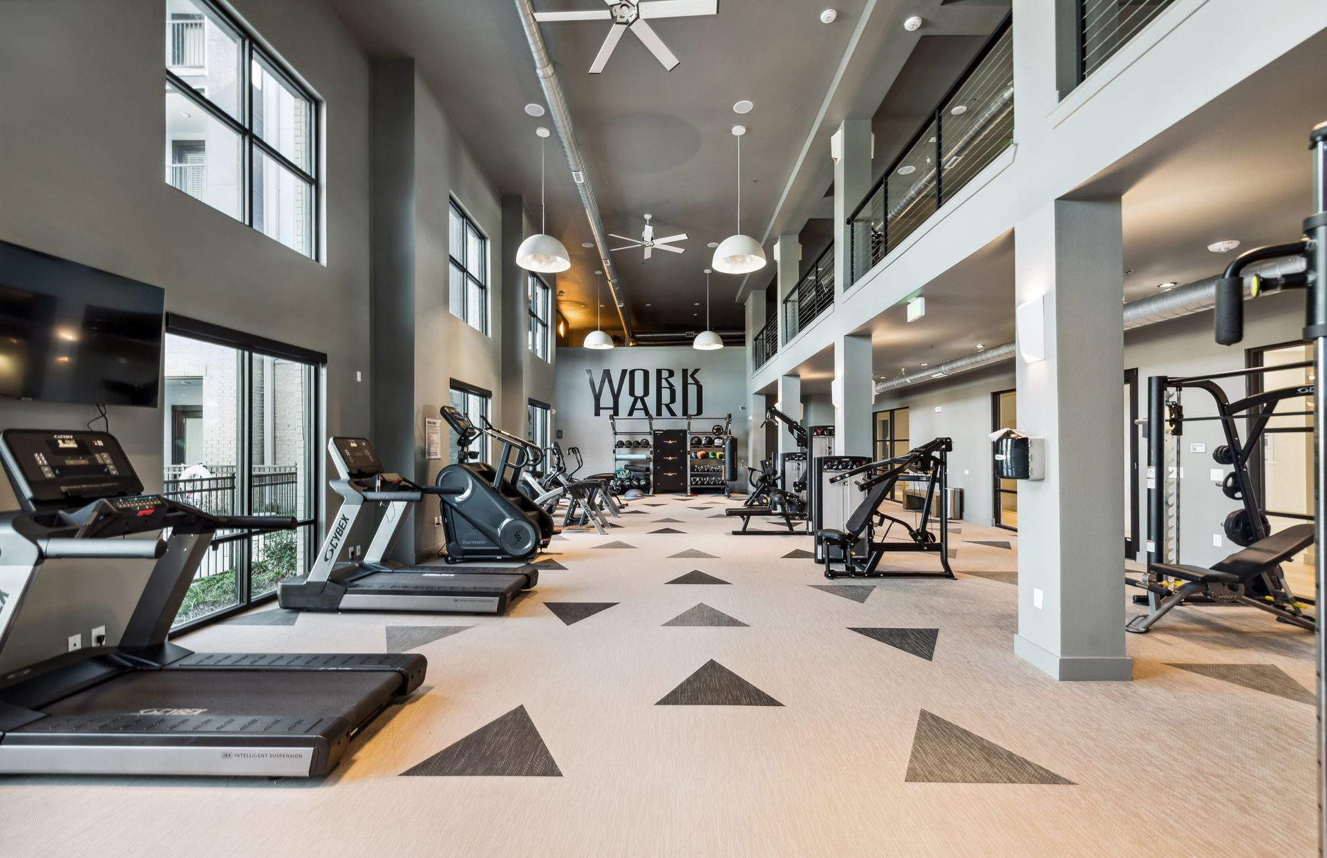 Gym interior with exercise equipment, including treadmills, stair climbers, and more at One90 Gateway in Plano, TX.