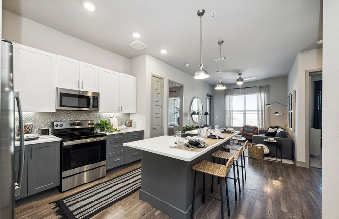 Modern kitchen with hardwood-style flooring at One90 Gateway in Plano, TX.