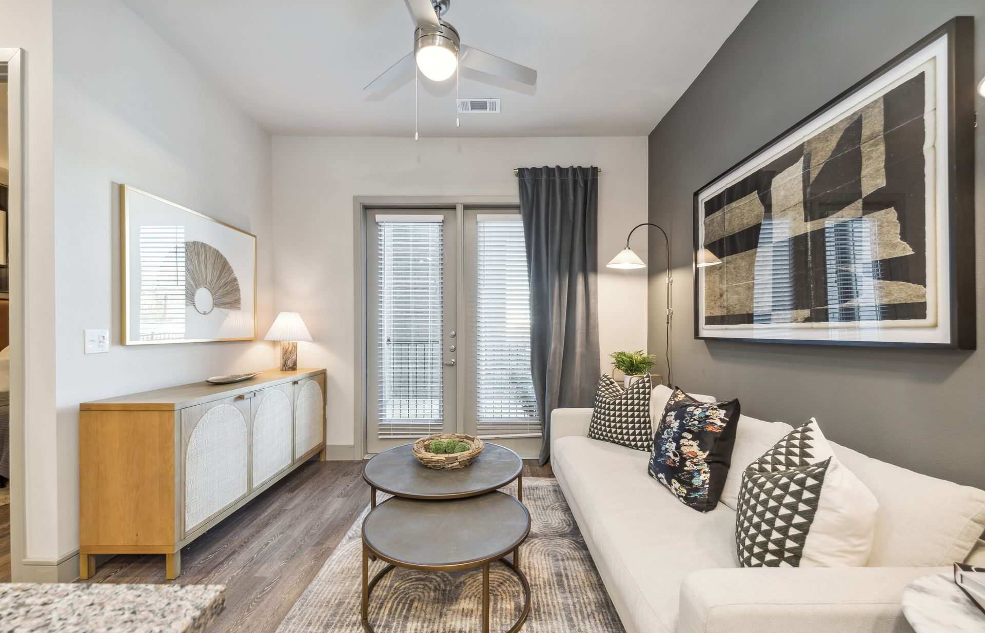 Modern living room with a ceiling fan and contemporary furnishings at One90 Gateway in Plano, TX.