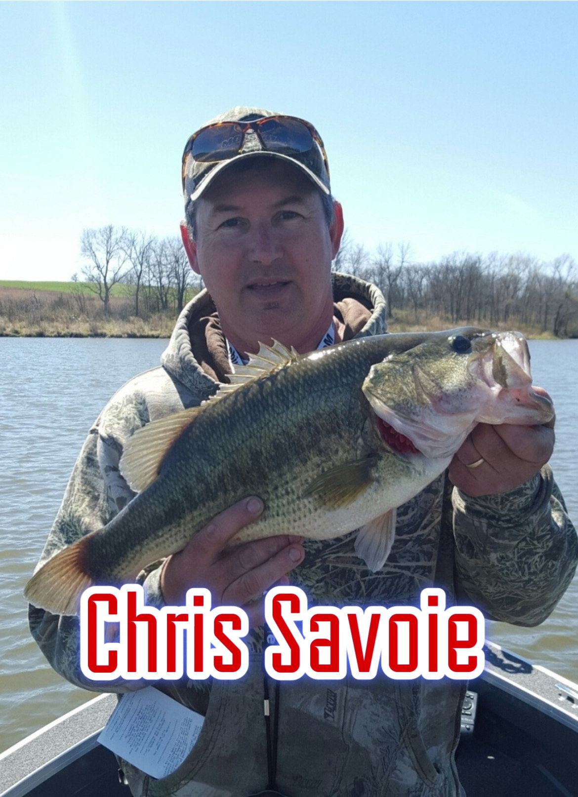 Man holding a large bass on a boat, with “Chris Savoie” text overlaid.