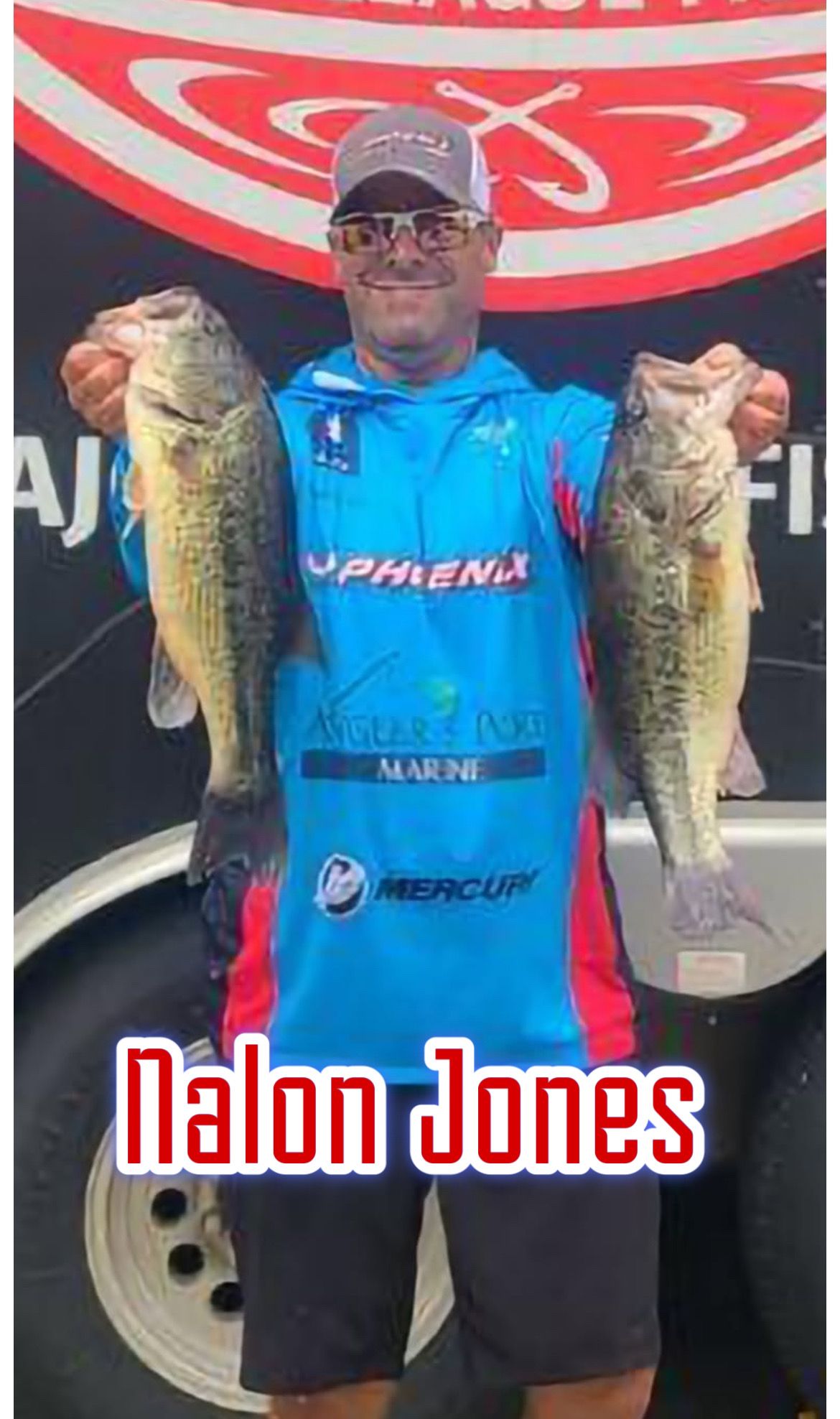 Angler in blue jersey holding two large fish in front of a boat or tournament backdrop, labeled “Nalon Jones”