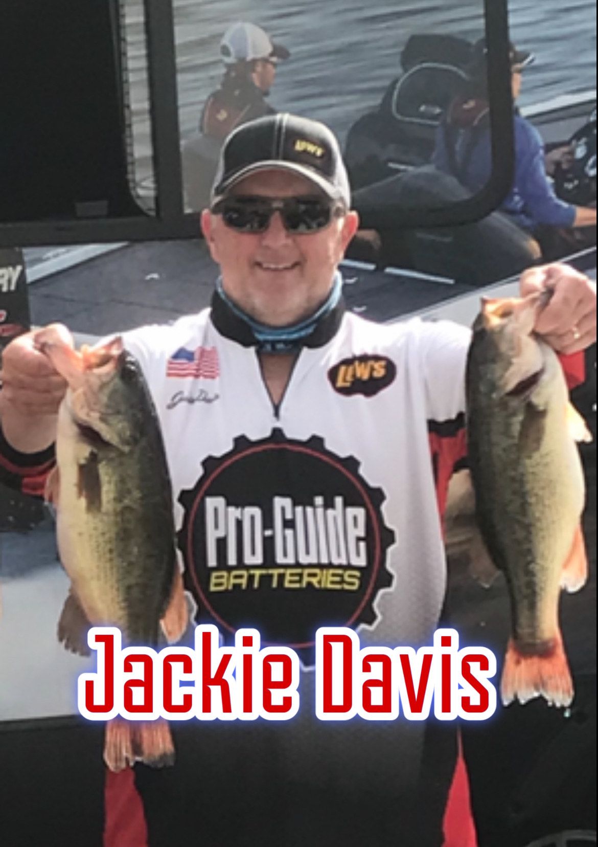 Jackie Davis smiling and holding two largemouth bass at a fishing weigh-in event