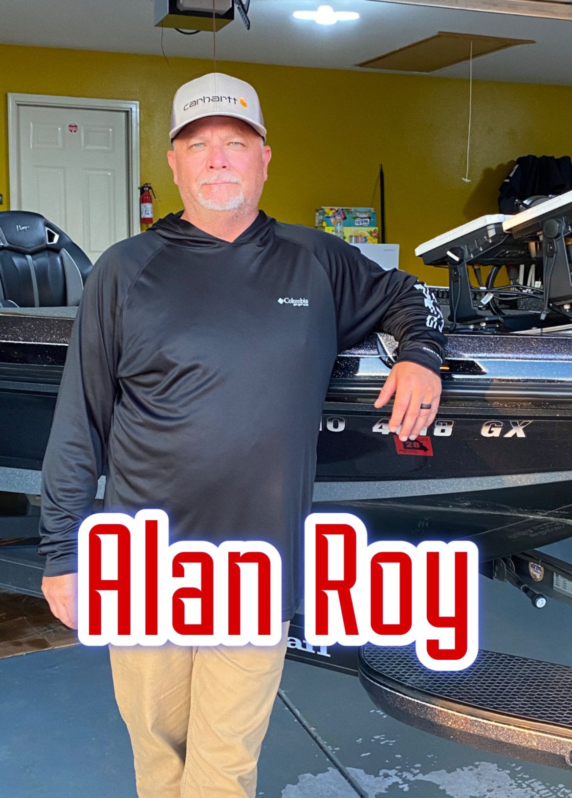 Man in a black shirt and cap leaning on a boat indoors, with “Alan Roy” text overlay.