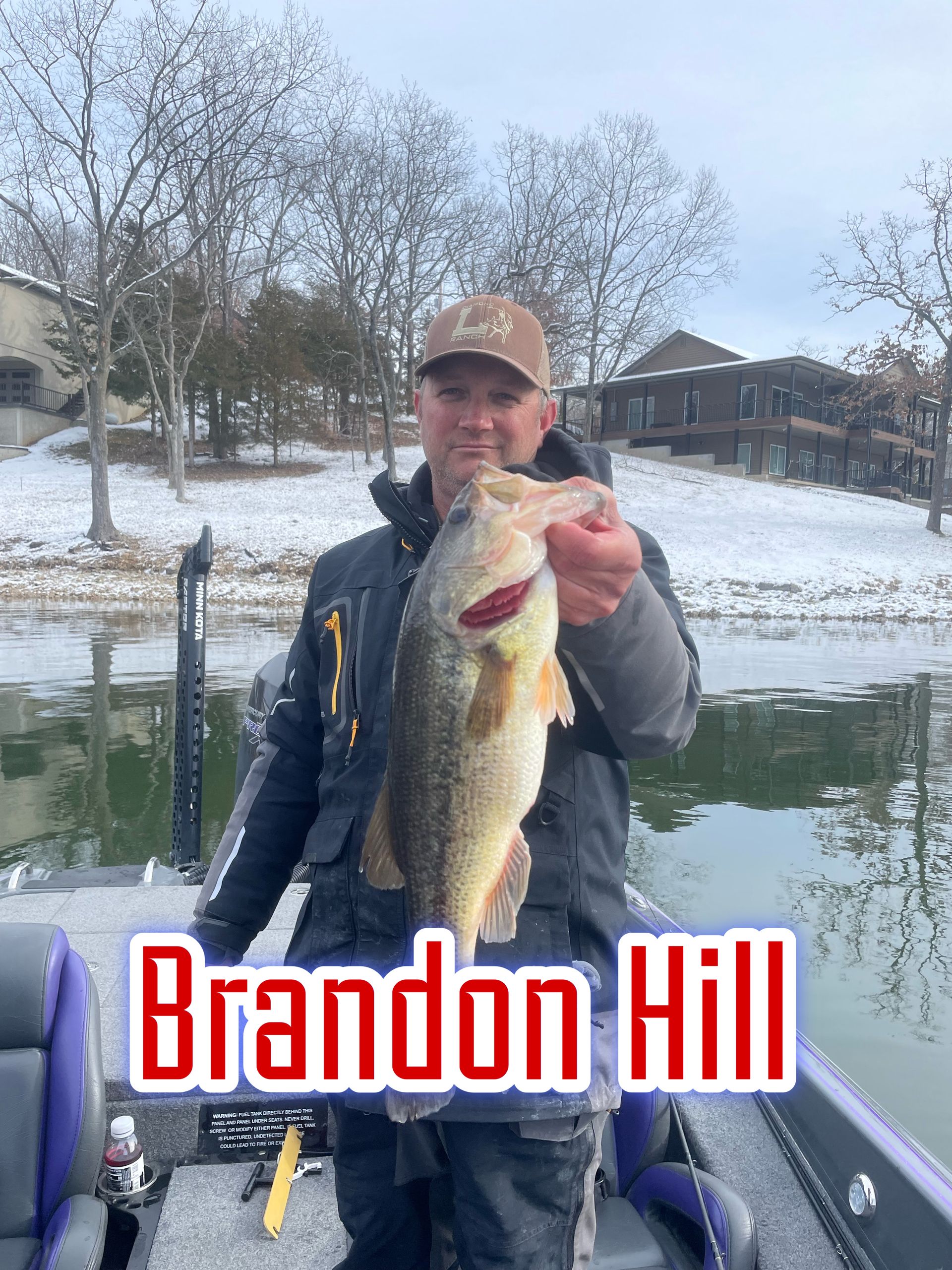 Man holding a large fish on a boat in a snowy lakeside setting, with “Brandon Hill” text overlay.