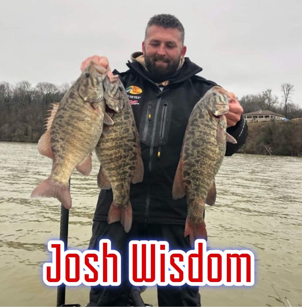 Man holding two large fish by a river; “Josh Wisdom” text at bottom.
