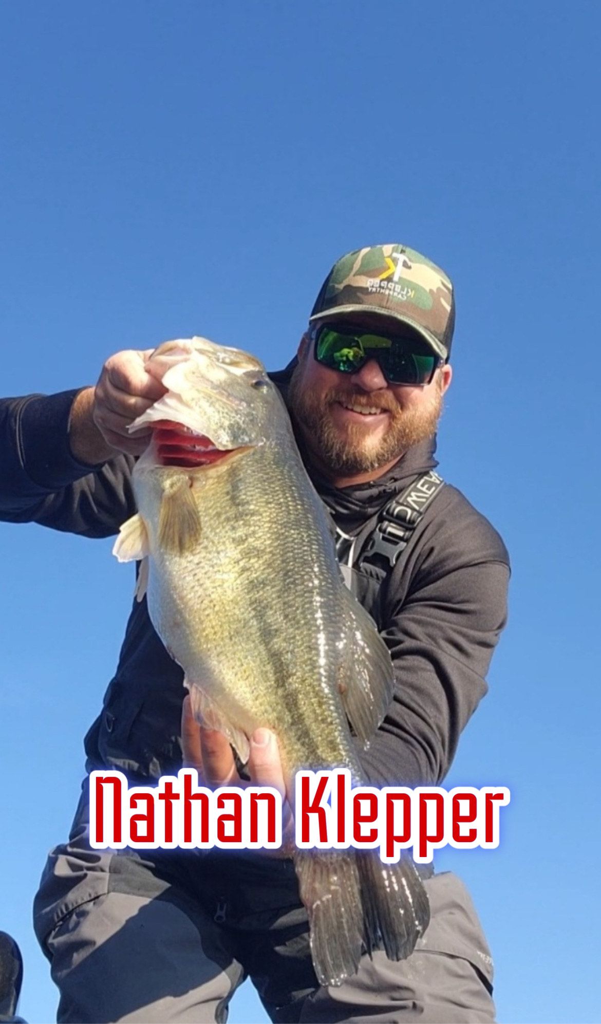 Man holding a large fish against a blue sky, with “Nathan Klepper” text at the bottom