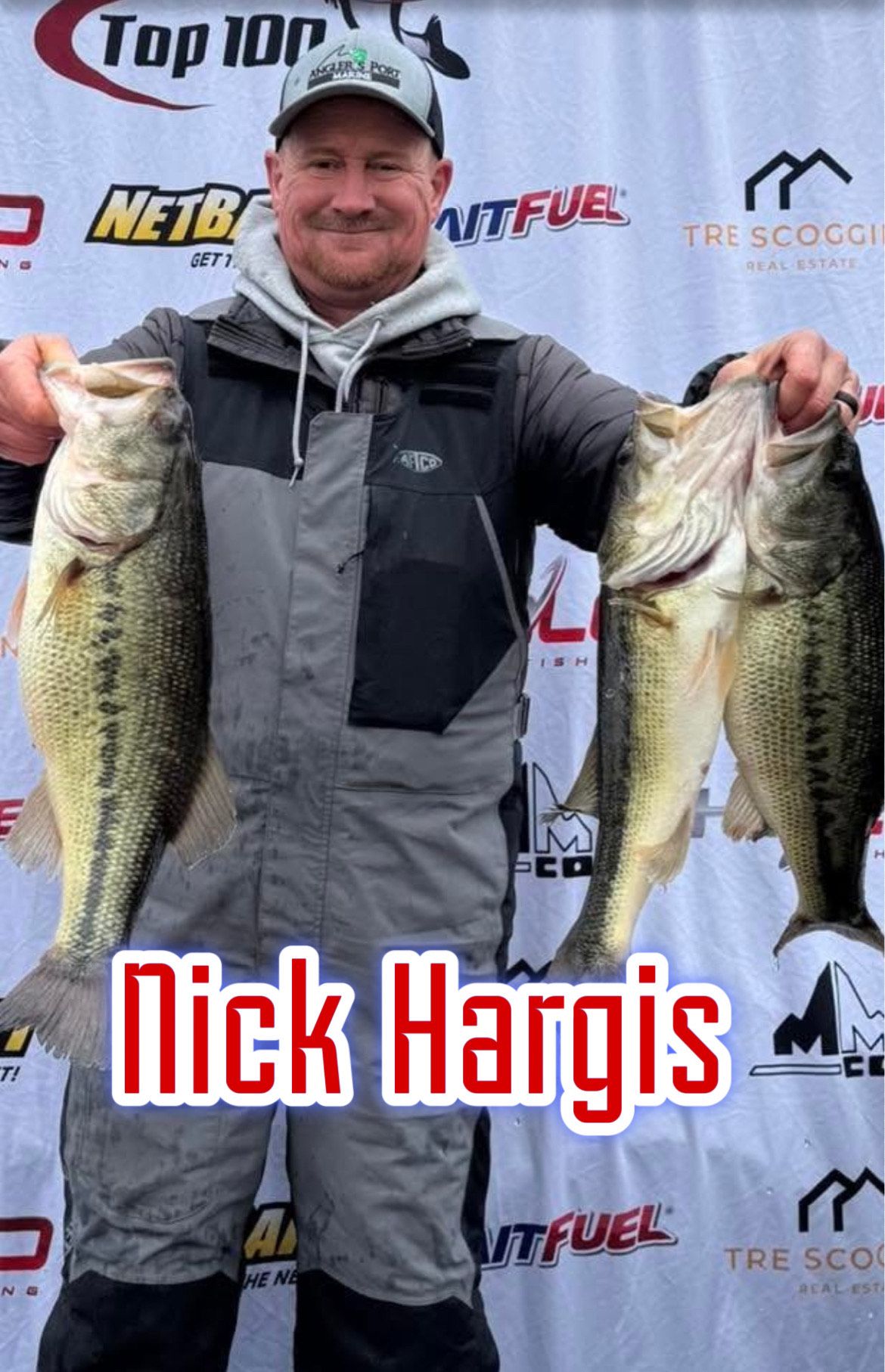 Man in gray jacket holding two large bass in front of a sponsor backdrop, labeled “Nick Hargis.”