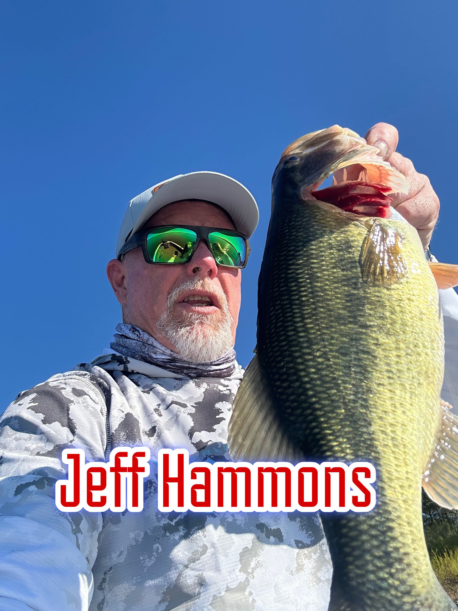 Man holding a large fish against a clear blue sky, with “Jeff Hammons” text at the bottom