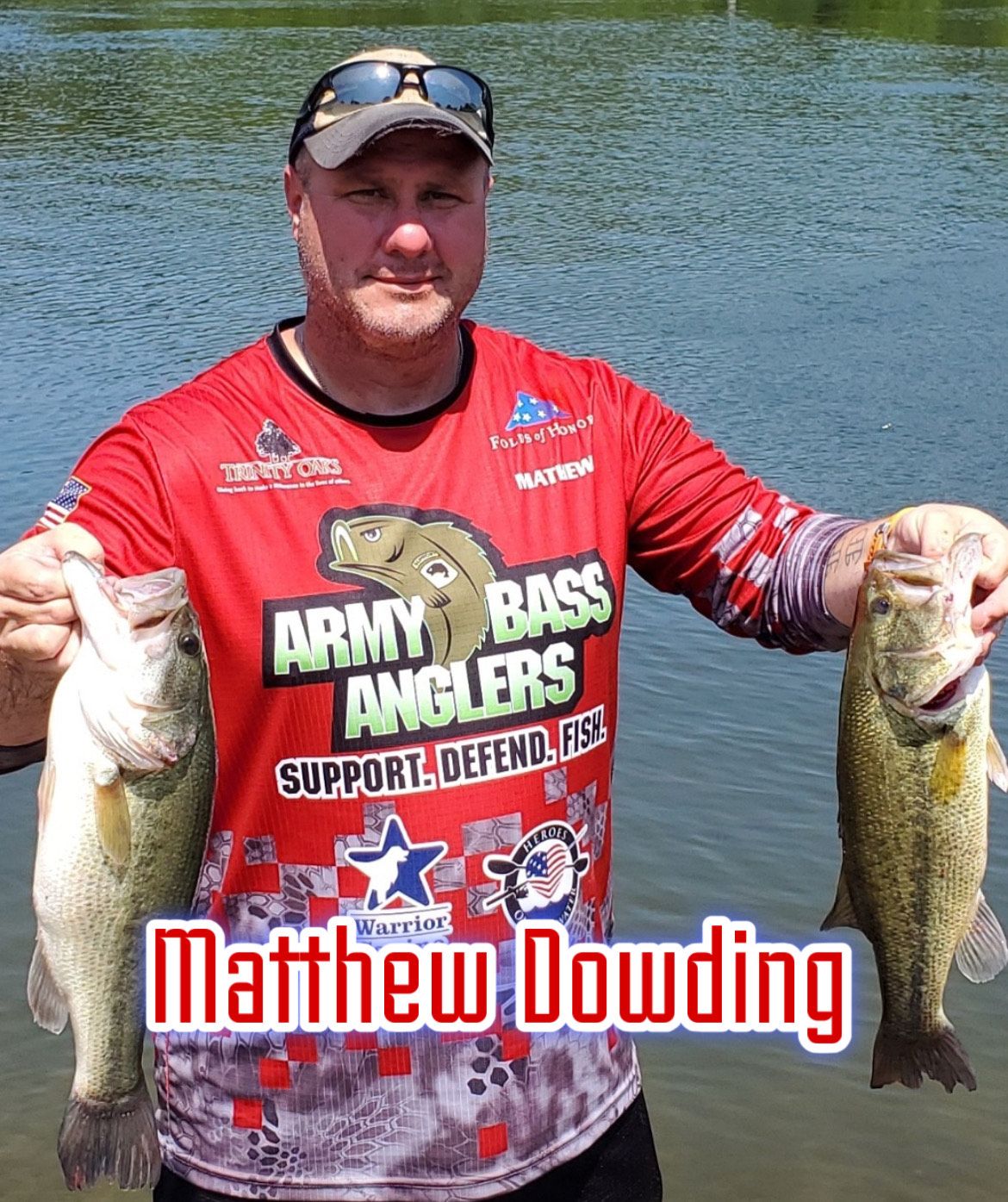 Angler in red jersey holding two fish by a lake, with “Matthew Dowding” text across the bottom.