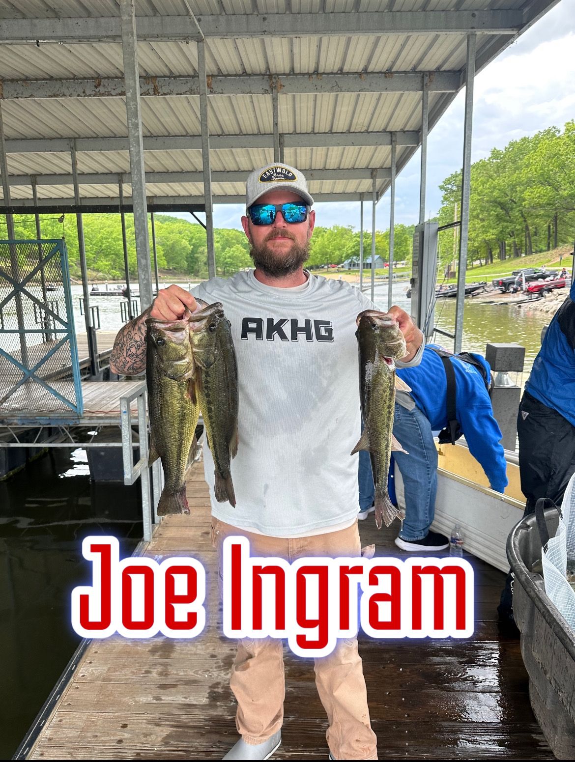 Man holding two large fish on a dock under a covered pavilion, with “Joe Ingram” text overlaid