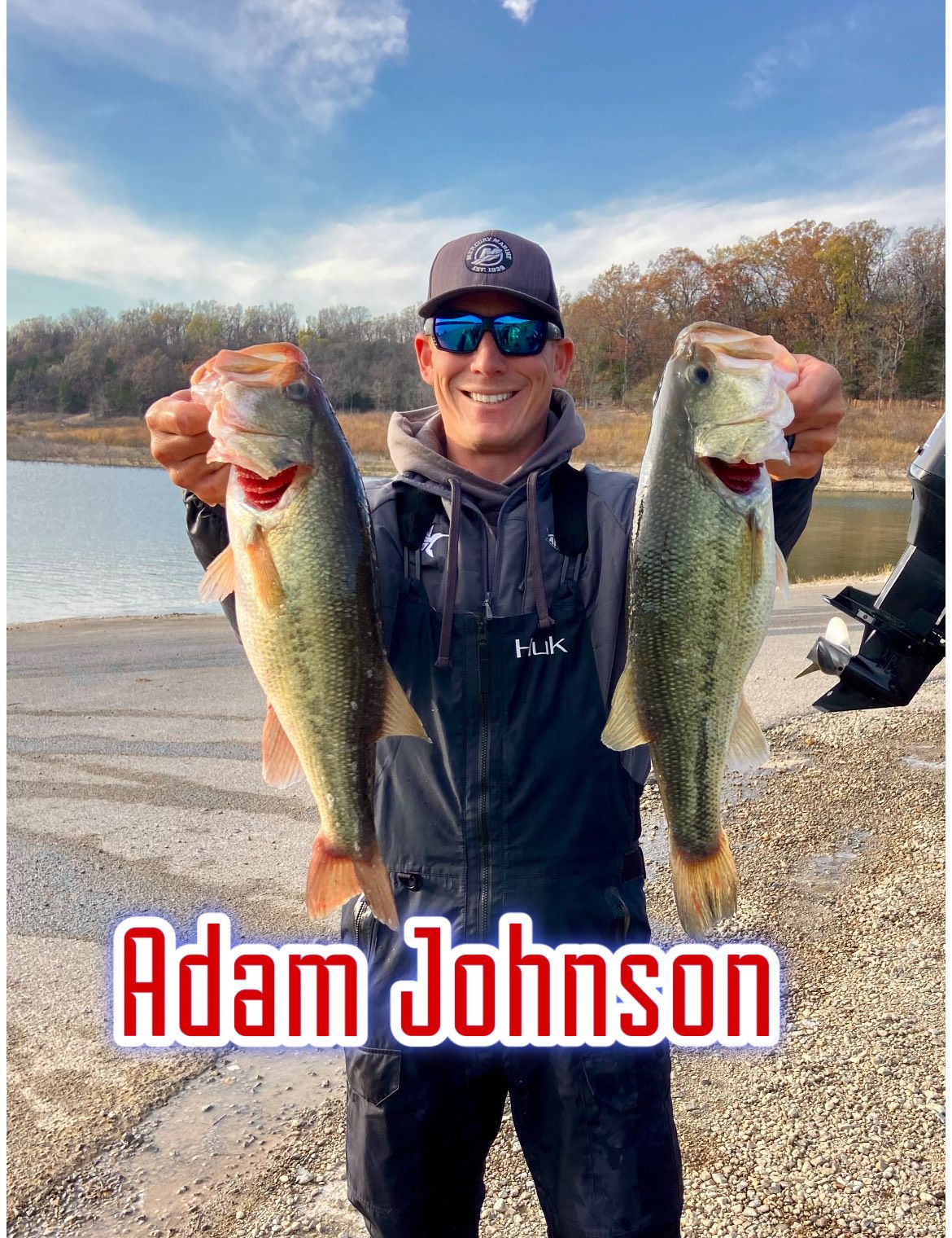 Man holding two large fish by a lake, wearing a cap and sunglasses; text reads “Adam Johnson”