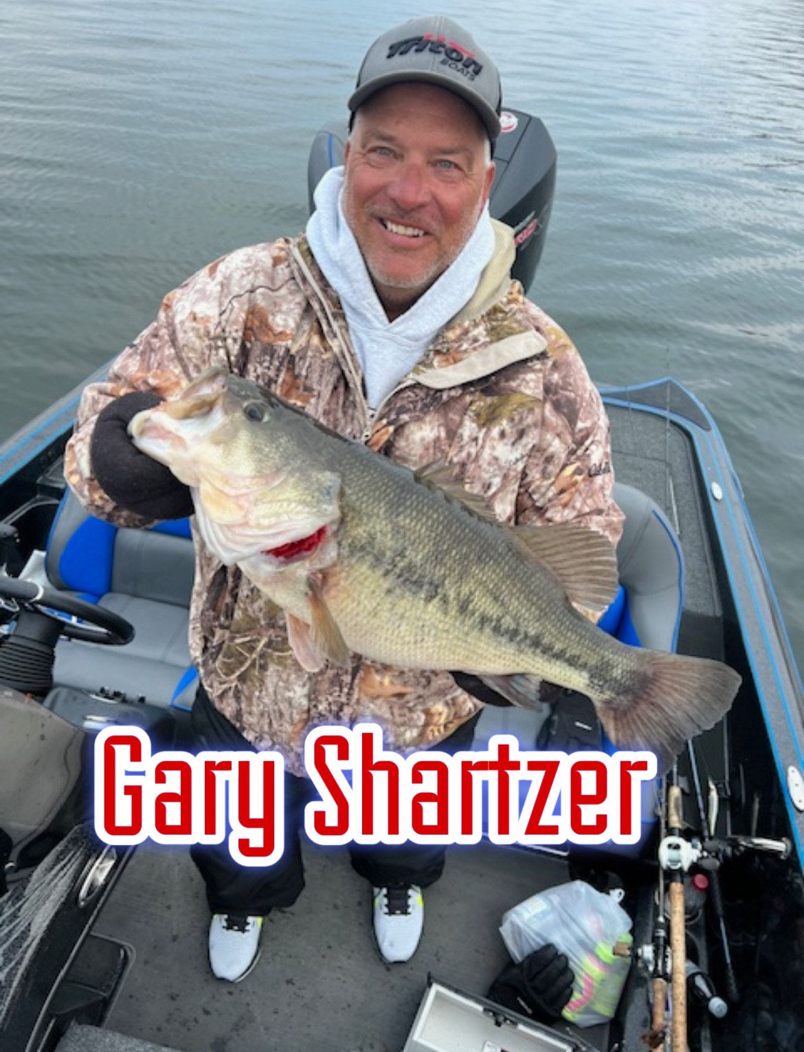 Man smiling in a boat holds a large fish, with the name “Gary Shartzer” overlaid
