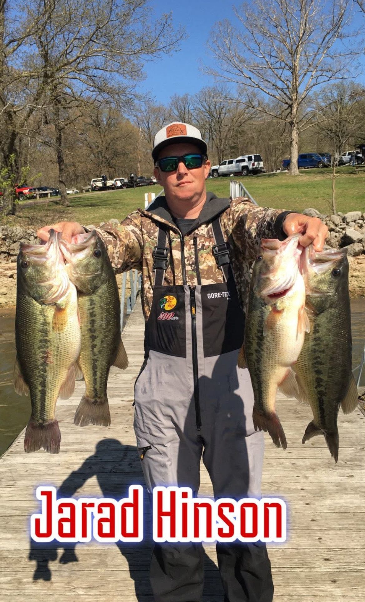 Angler holding two large fish in a sunny park, with “Jarad Hinson” text at the bottom