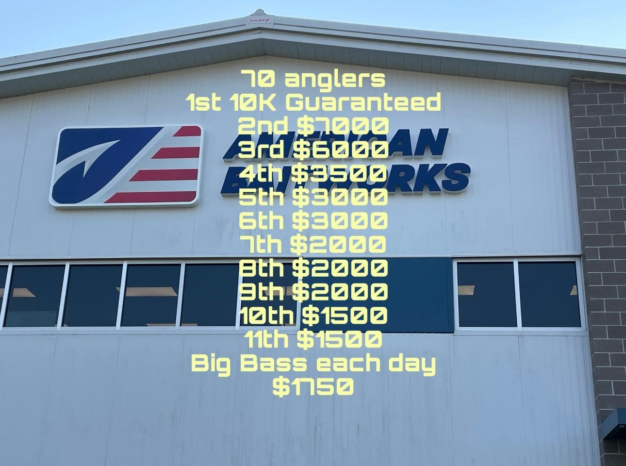 Building sign listing tournament payouts and “Big Bass cash day,” with red, blue, yellow text on white wall