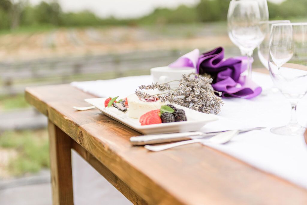 A wooden table topped with plates of food and wine glasses.