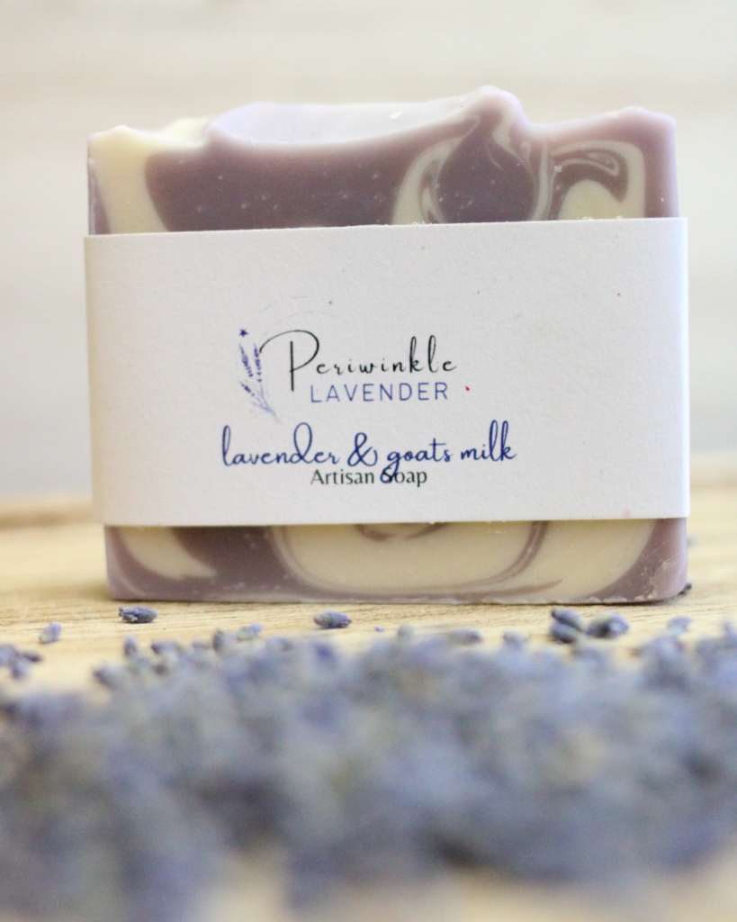 A bar of lavender soap is sitting on a wooden table