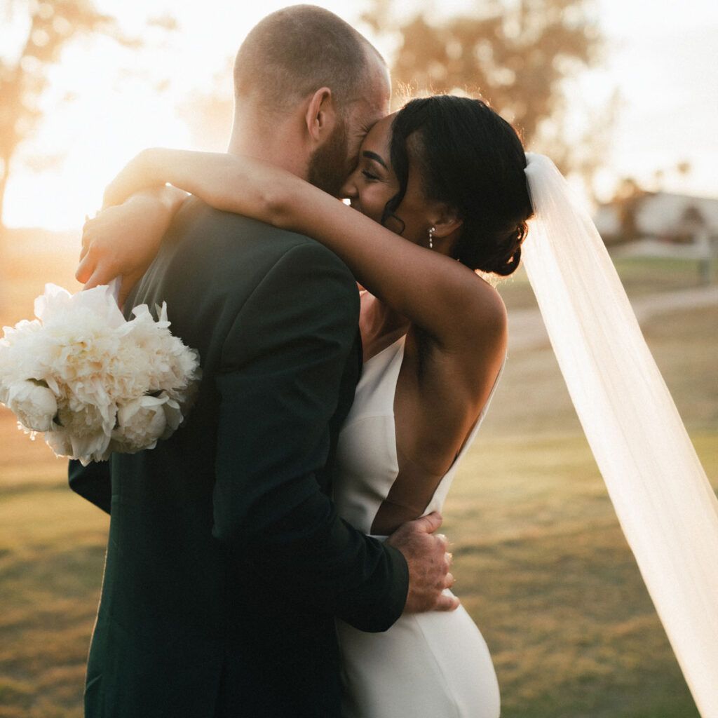 A bride and groom are kissing on their wedding day.