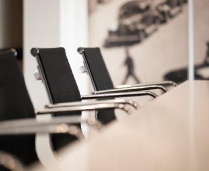 Sillas de oficina negras alineadas en una moderna sala de conferencias.