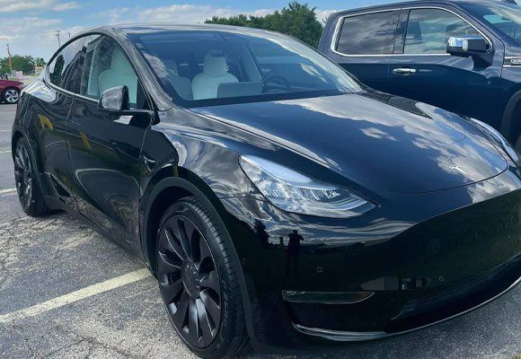 Black Tesla Model Y parked in a parking lot.
