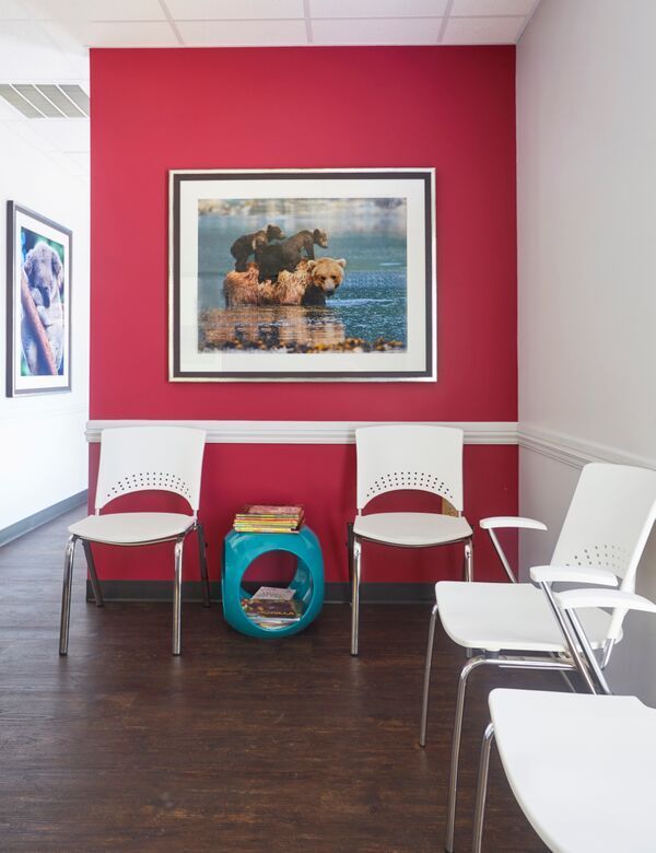 A waiting room with chairs and a picture on the wall
