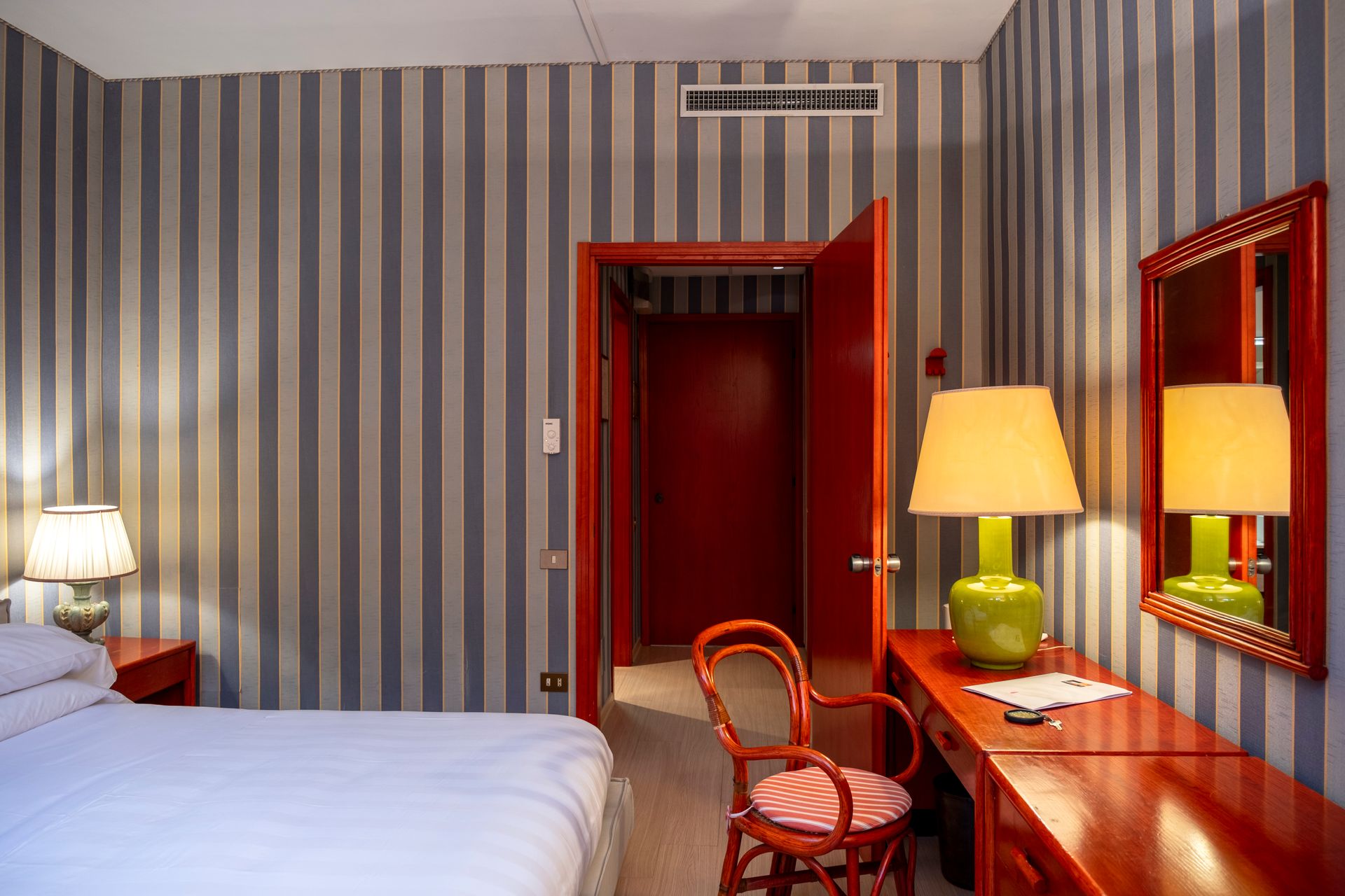 Гостиничный номер с кроватью, столом, стулом и лампами