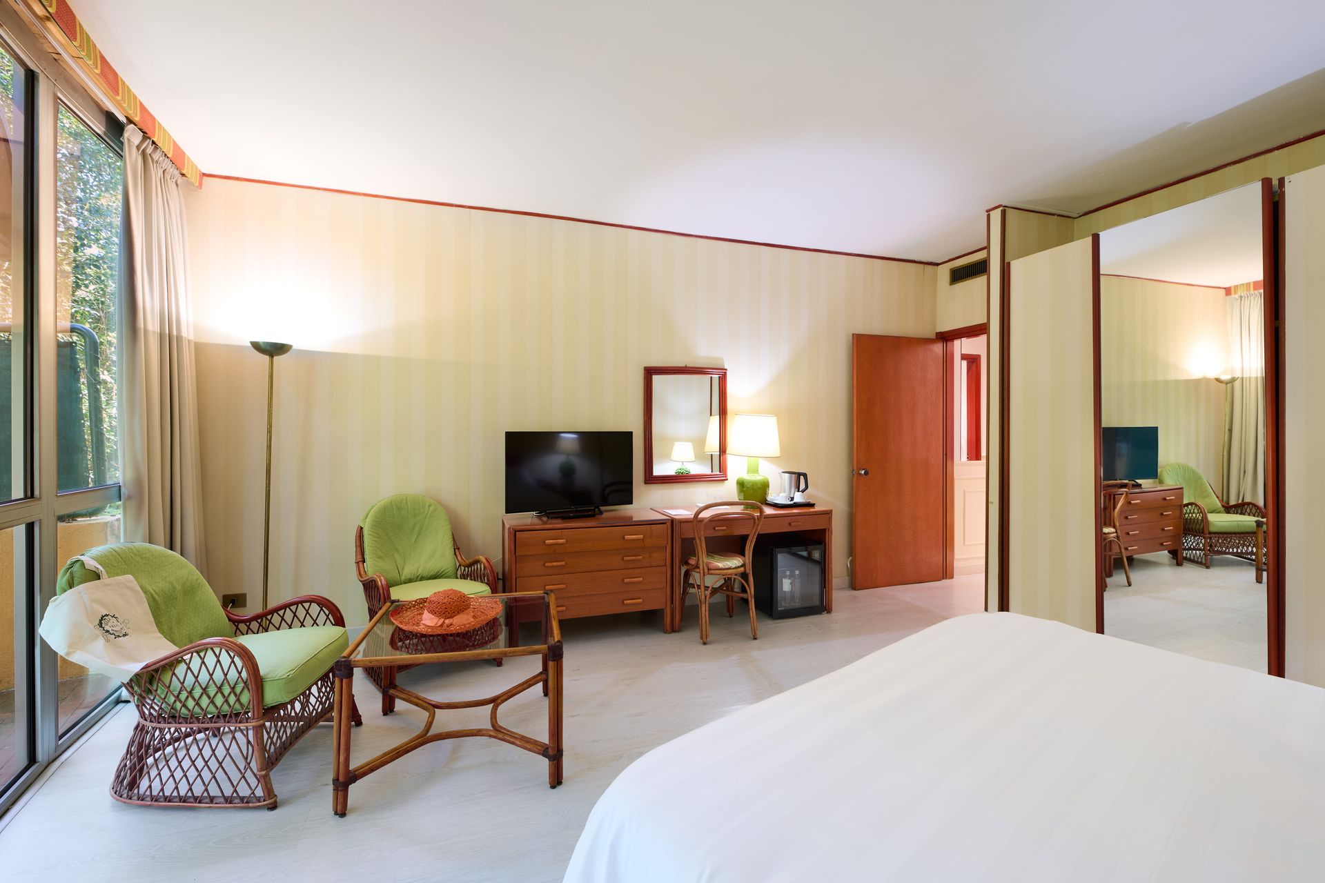 Гостиничный номер с кроватью, стульями, письменным столом и телевизором