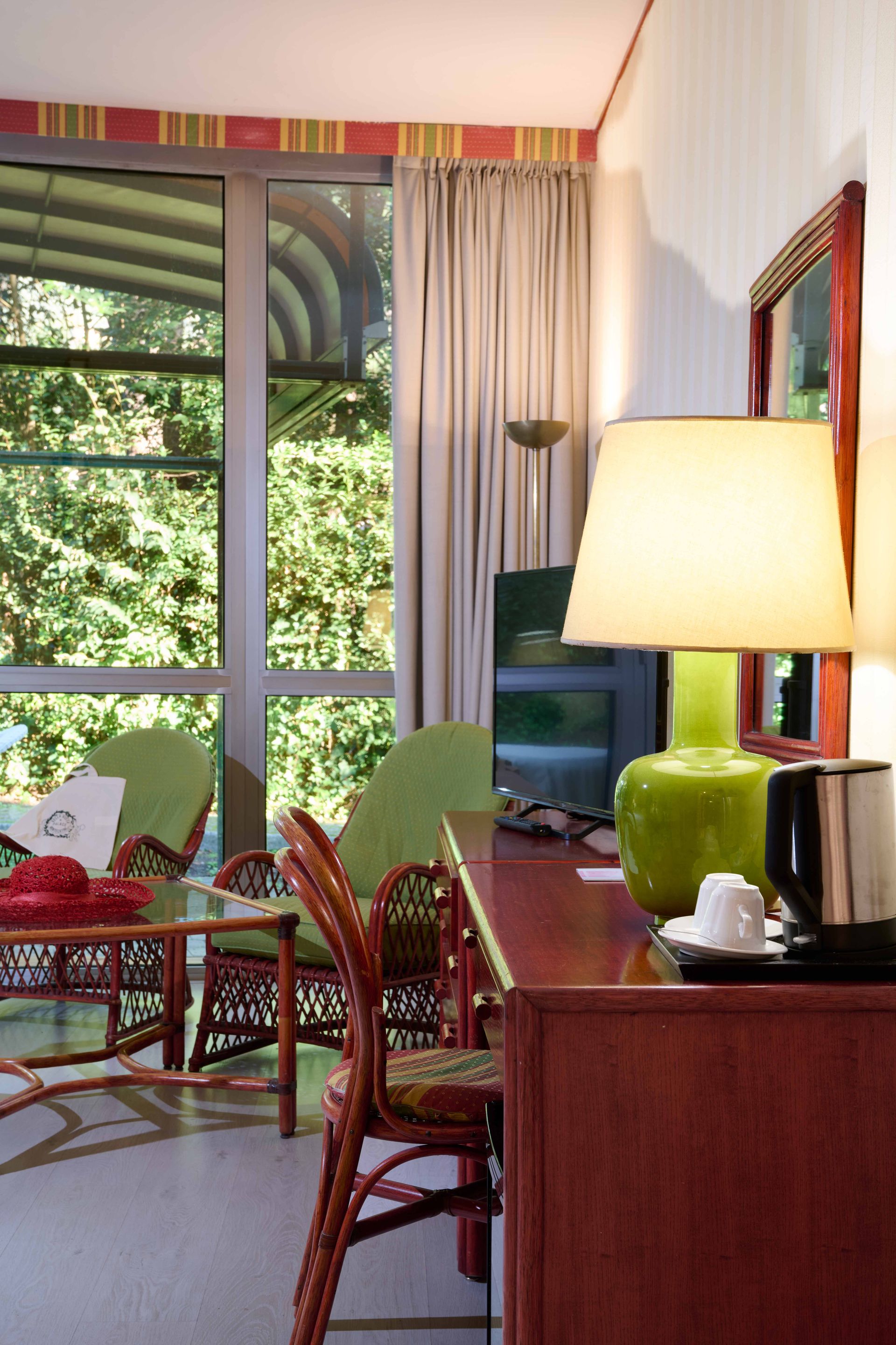 Гостиничный номер с письменным столом, стульями и лампой