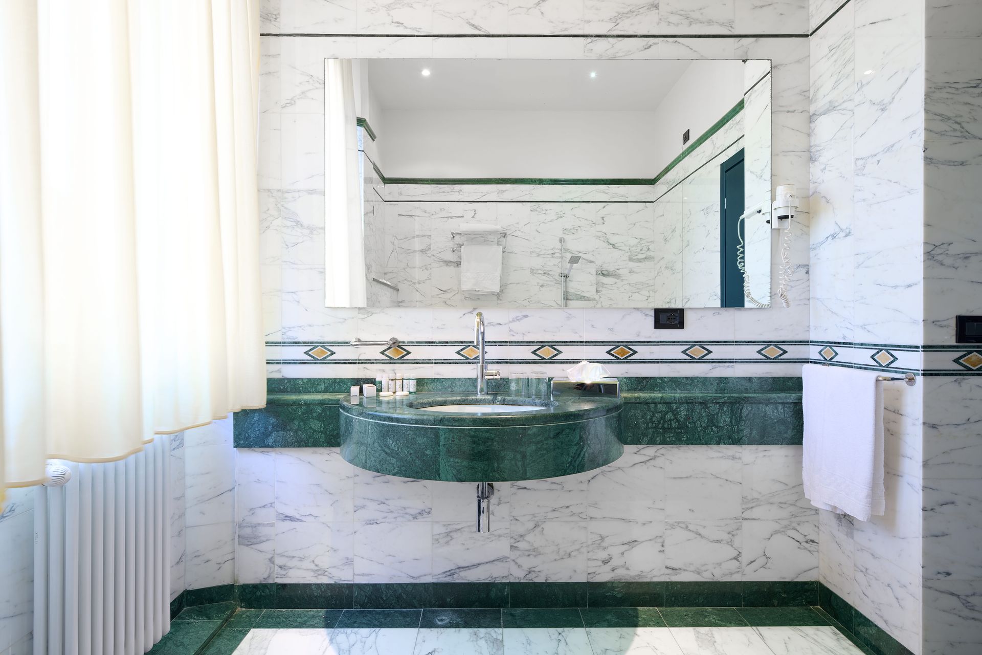 Ванная комната с зеленой раковиной и большим зеркалом.