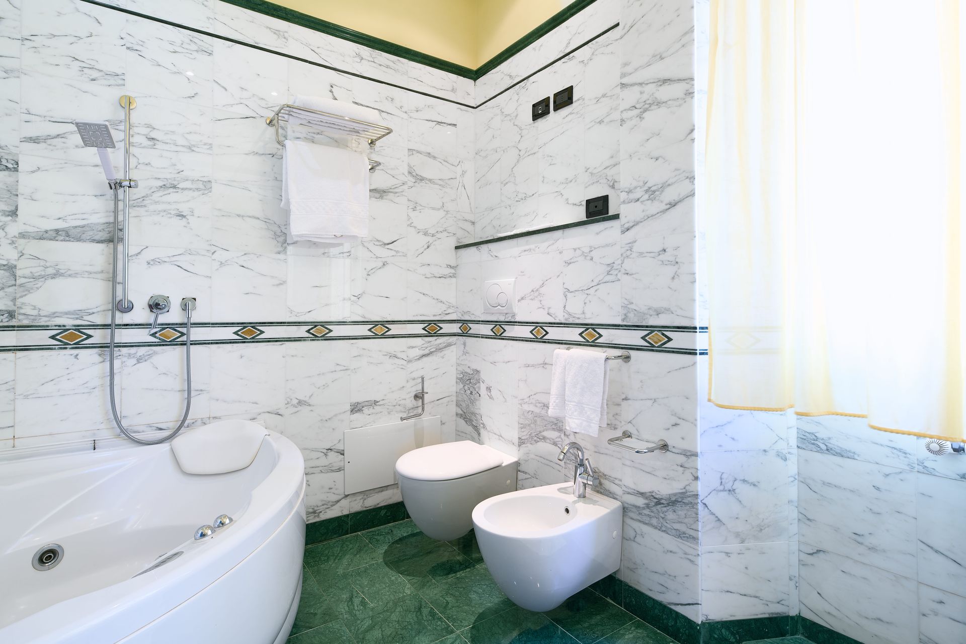 Ванная комната с двумя туалетами и ванной.