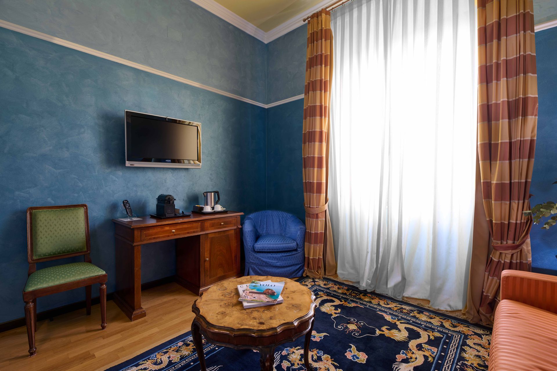 Гостиная со столом, стульями и телевизором с плоским экраном.