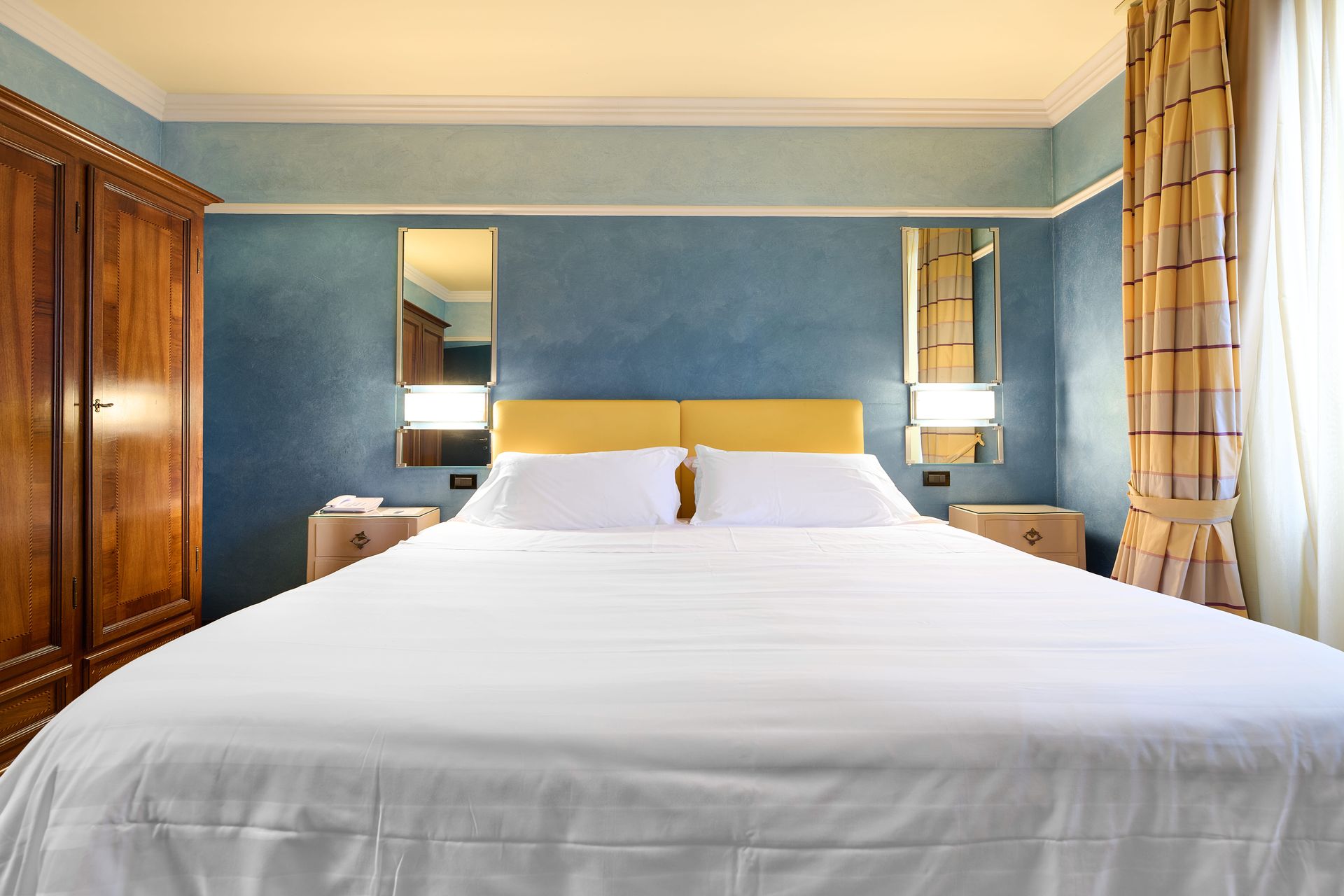 Гостиничный номер с большой кроватью и двумя зеркалами