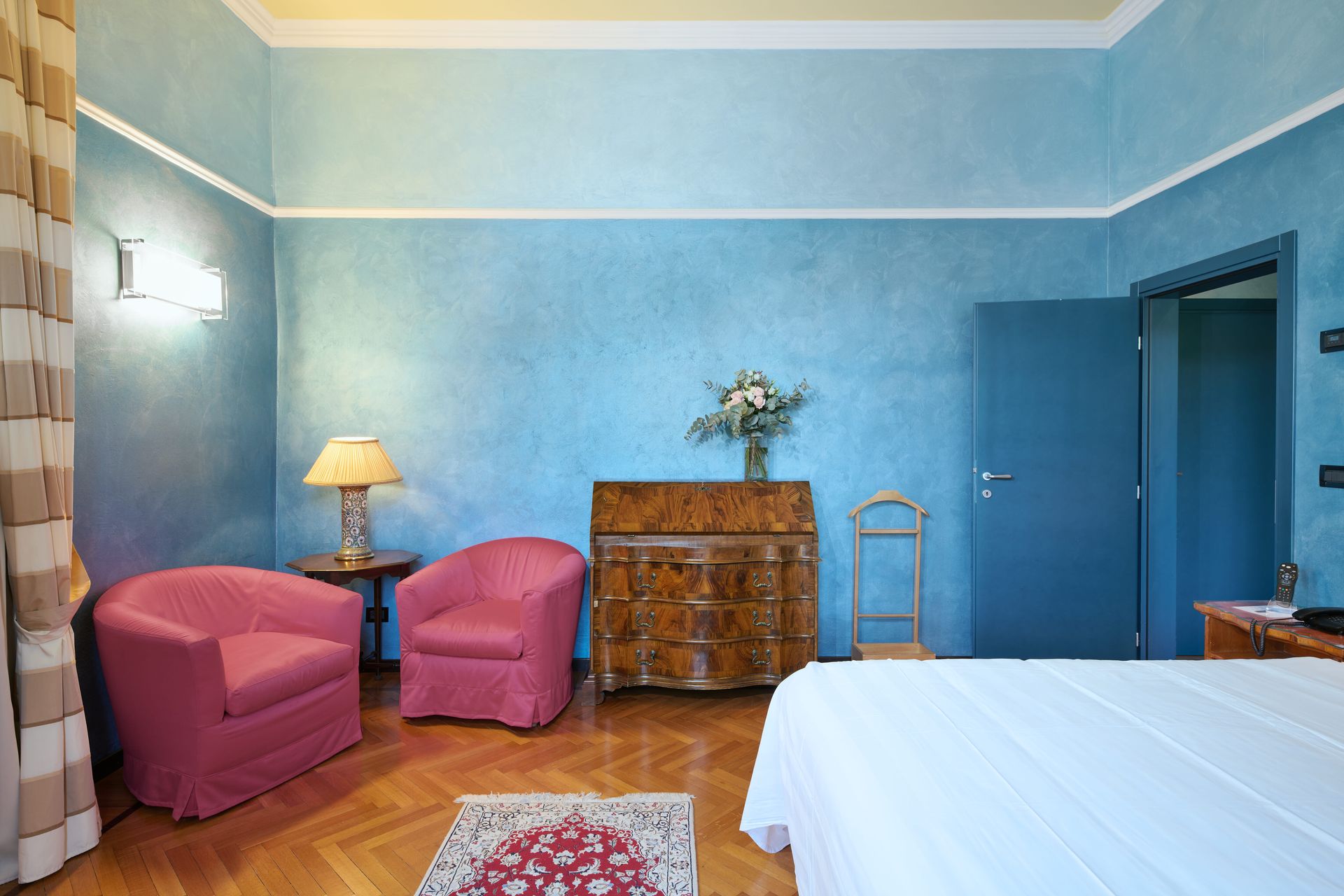 Спальня с синими стенами и розовыми стульями