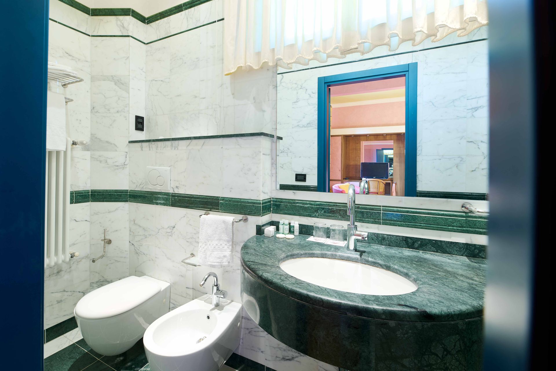 Ванная комната с двумя туалетами и раковиной