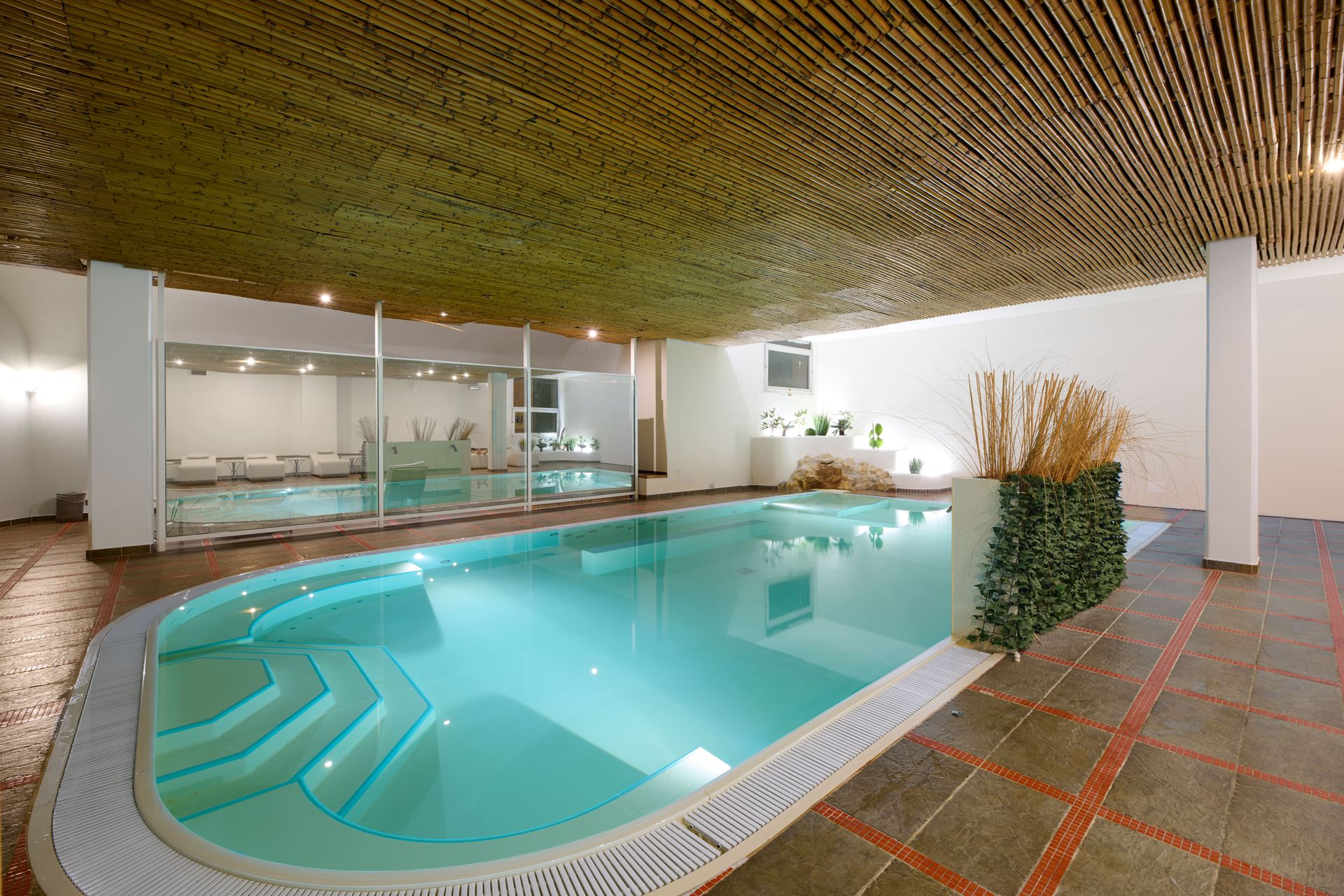 Una grande piscina coperta con soffitto in legno