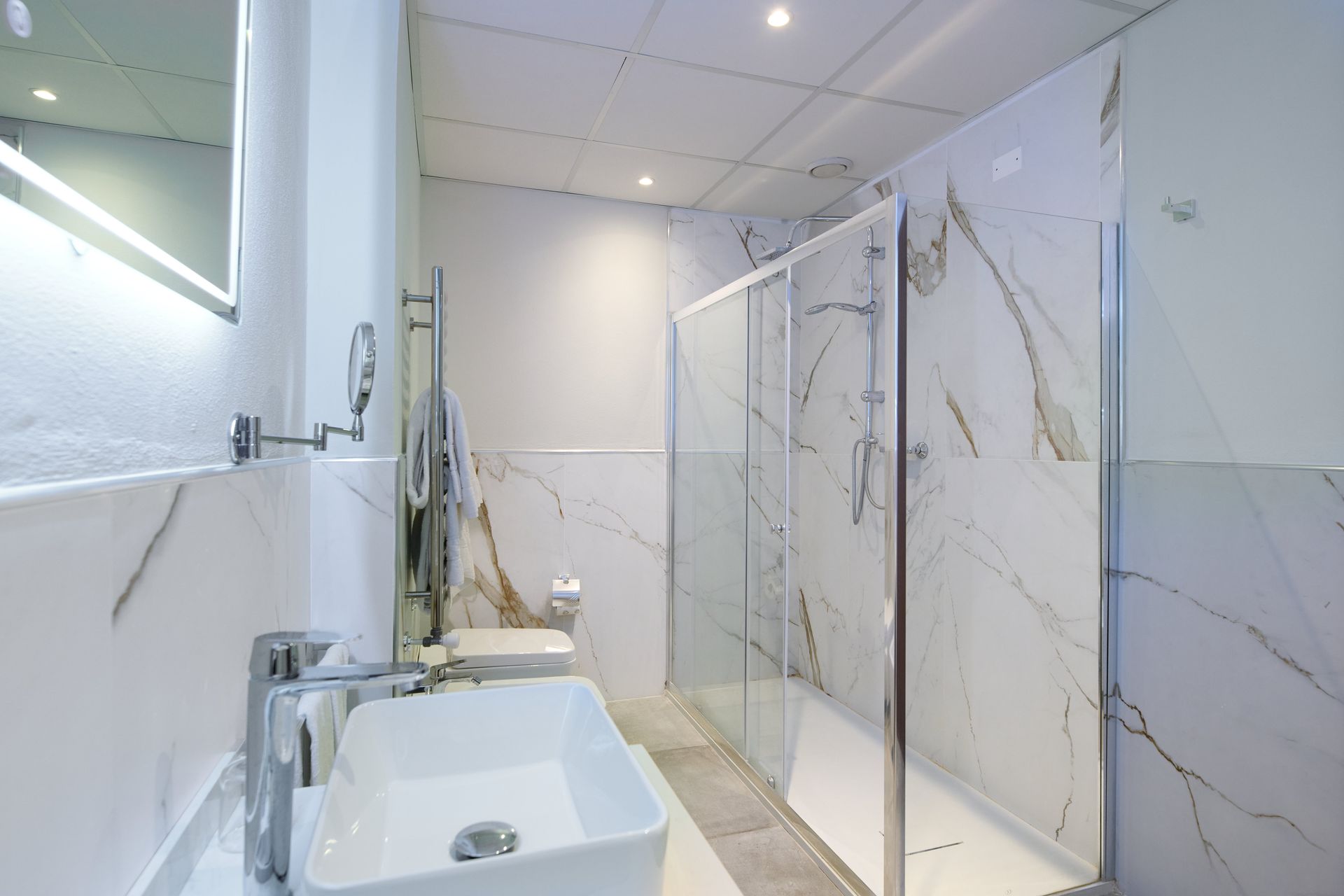 Ванная комната с раковиной, туалетом, душем и зеркалом.