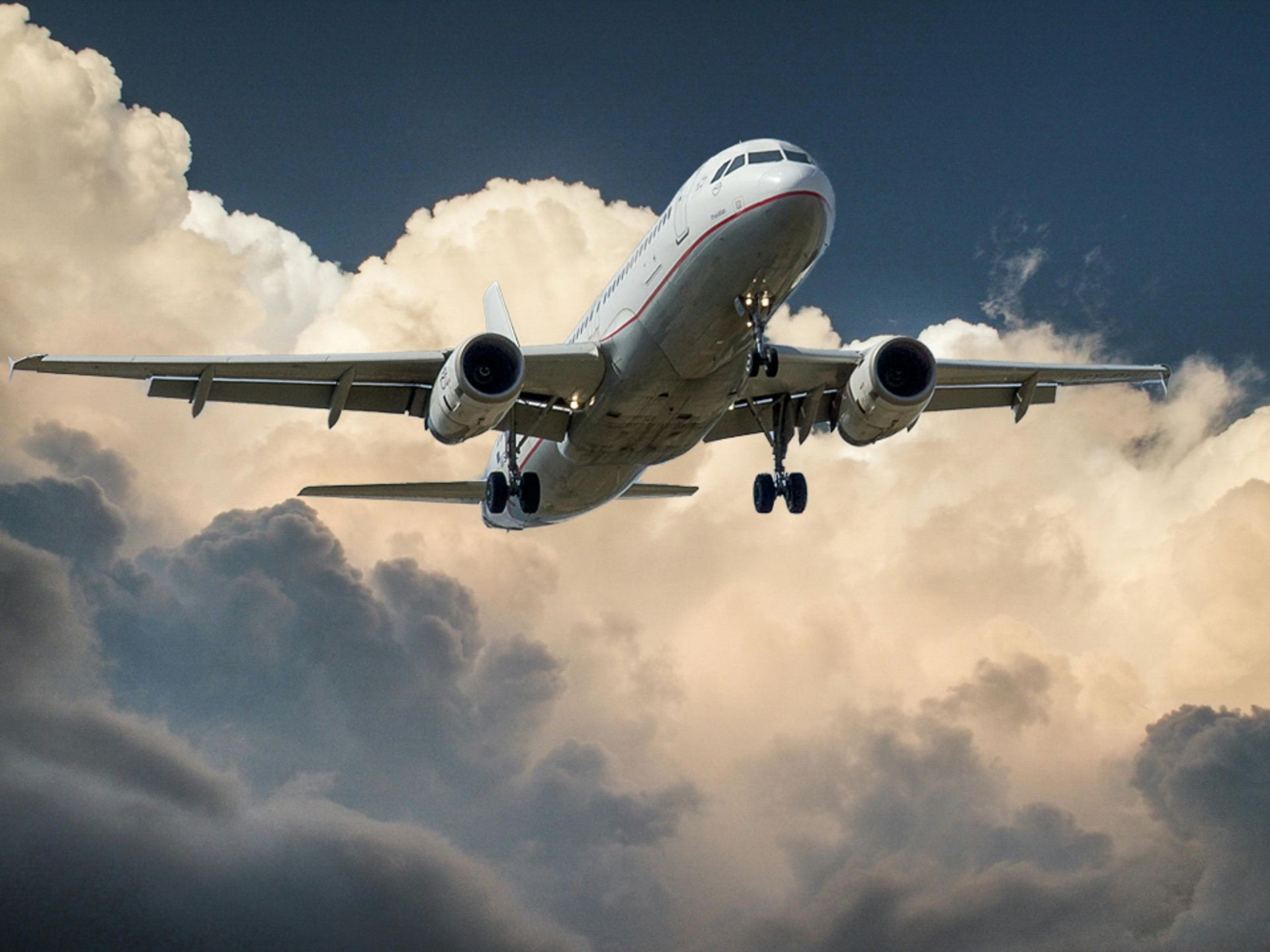 Un grande aereo passeggeri sta volando in un cielo nuvoloso.