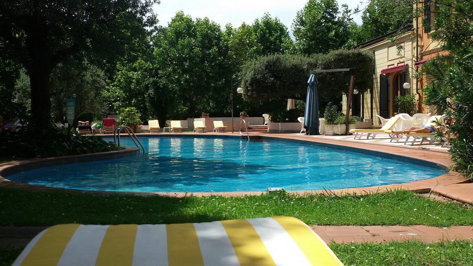 Una grande piscina con un asciugamano a strisce gialle e bianche in primo piano