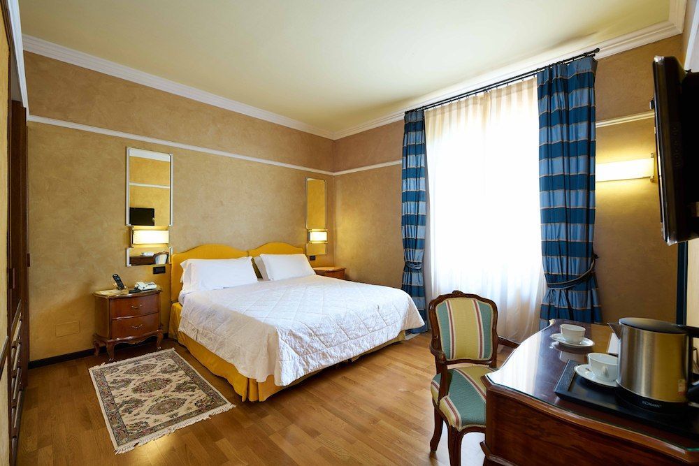 Una camera d'albergo con un letto grande e una scrivania