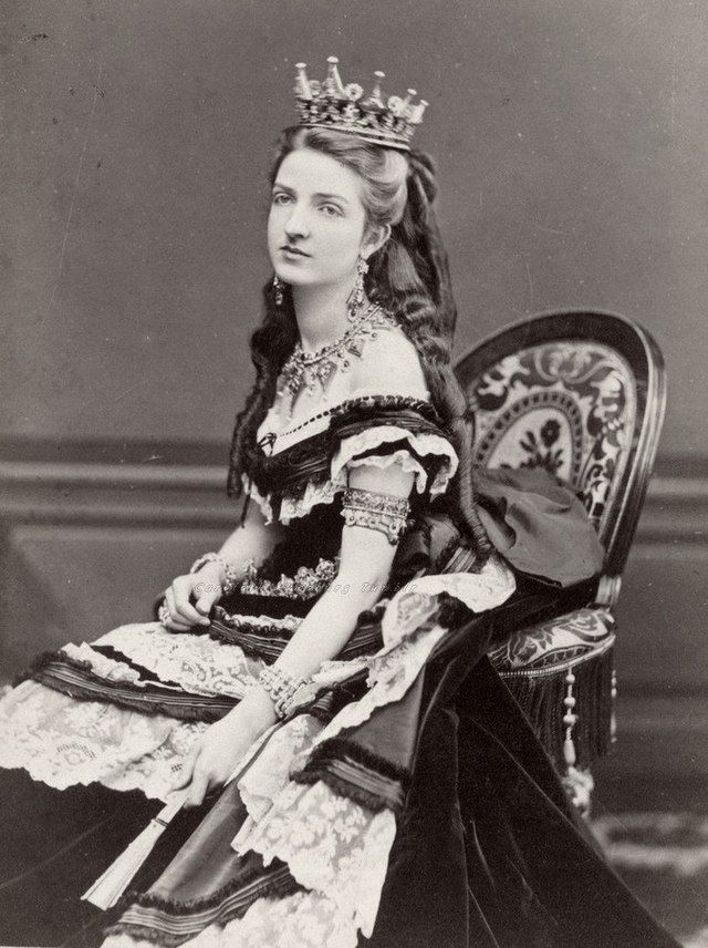 A woman wearing a crown is sitting in a chair