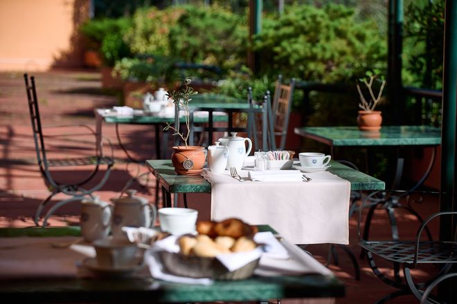 Un patio con tavoli e sedie allestiti per la colazione.