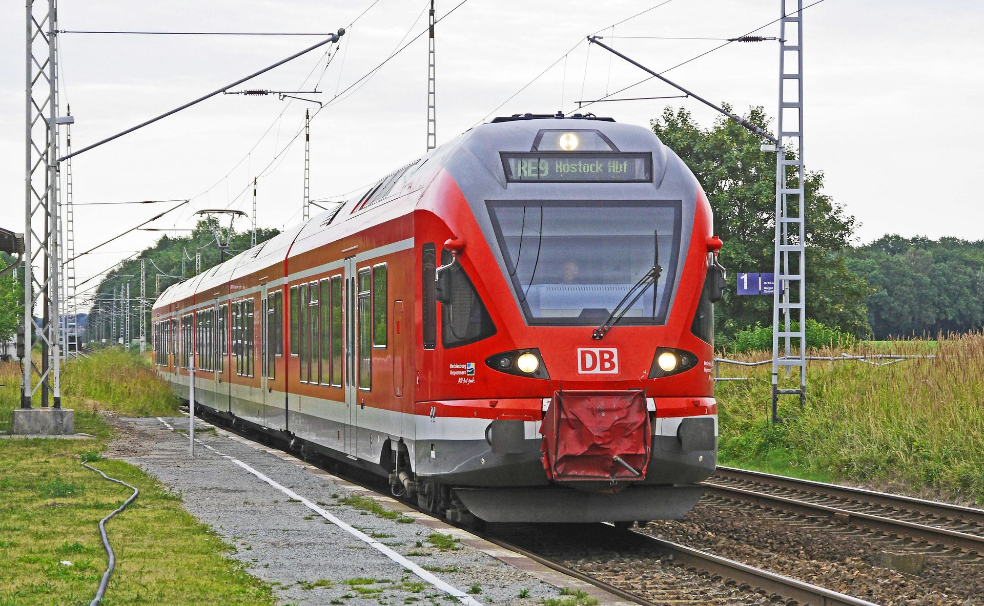 Un treno rosso e bianco sta procedendo lungo i binari.