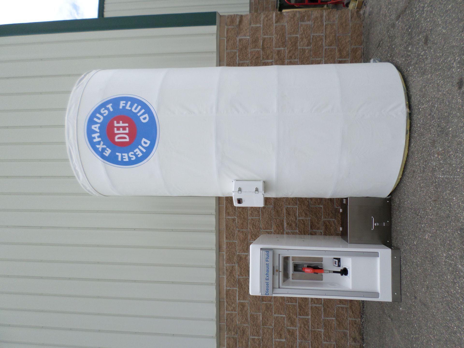 White DEF tank and dispenser outside, with blue 