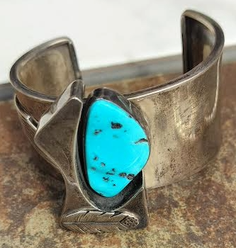 Turquoise stone in a silver cuff bracelet with an abstract leaf-like design