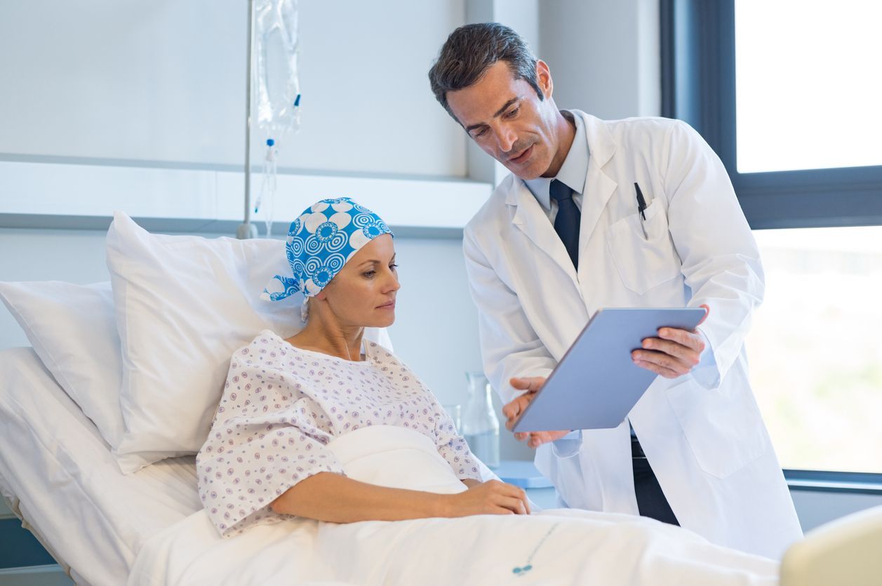 Doctor showing a chart to a patient in a hospital bed