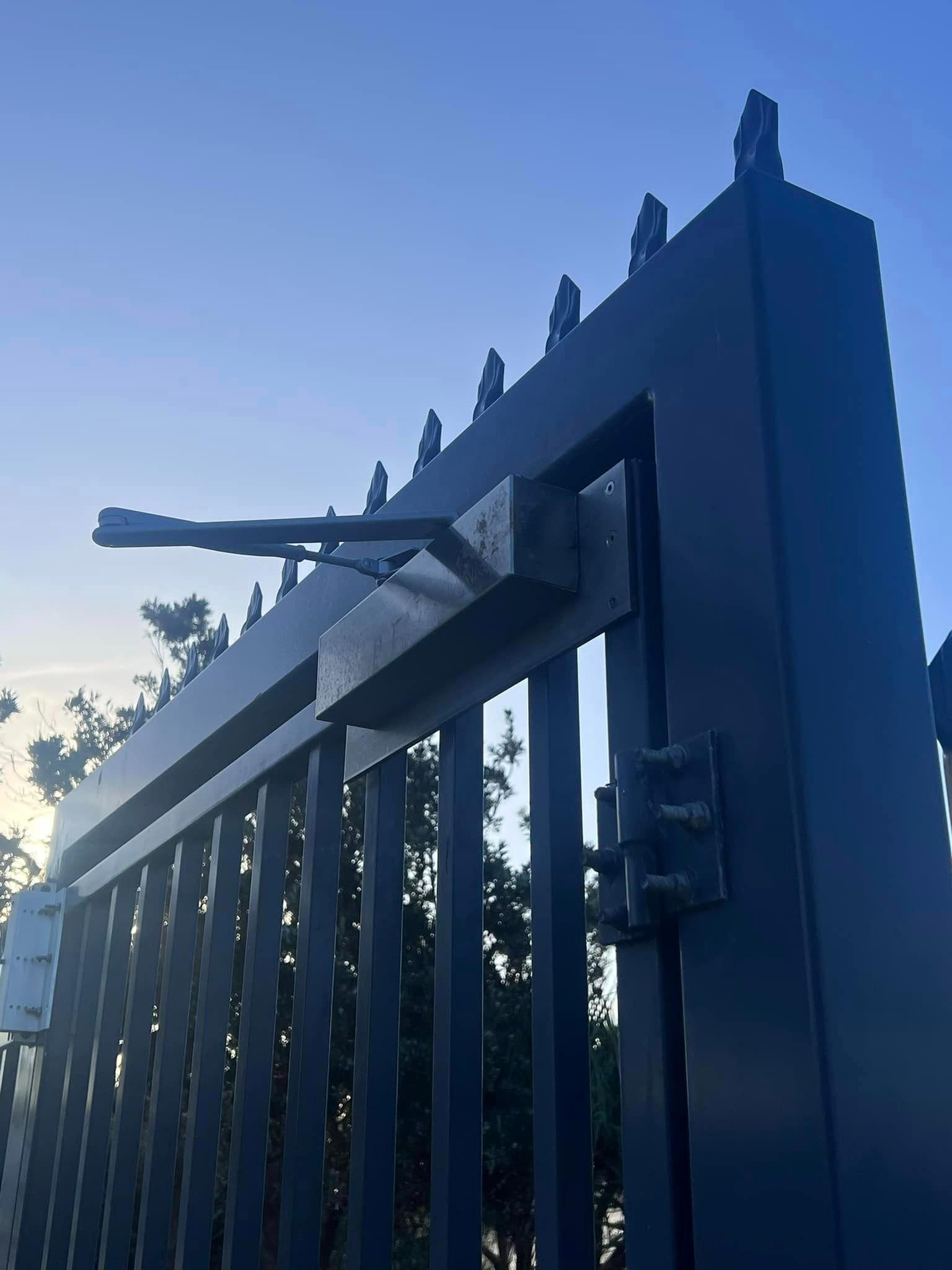 A Close up Of a Black Gate with A Blue Sky in The Background — Fortress Locksmiths & Security in Lennox Head, NSW