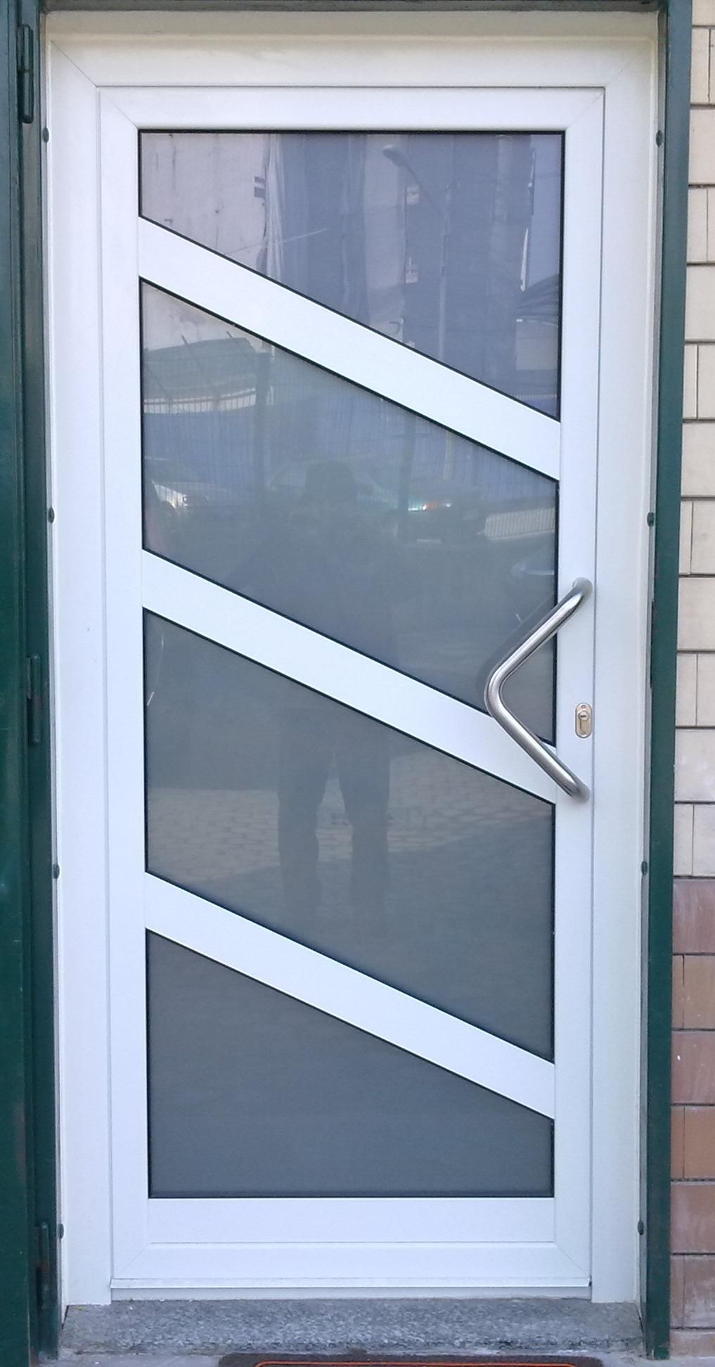 Porta di sicurezza bianca con barre diagonali e zanzariera. Maniglia argentata.