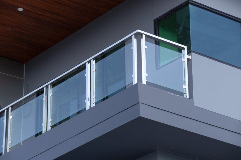 Esterno di un edificio moderno con ringhiera del balcone in vetro e metallo.