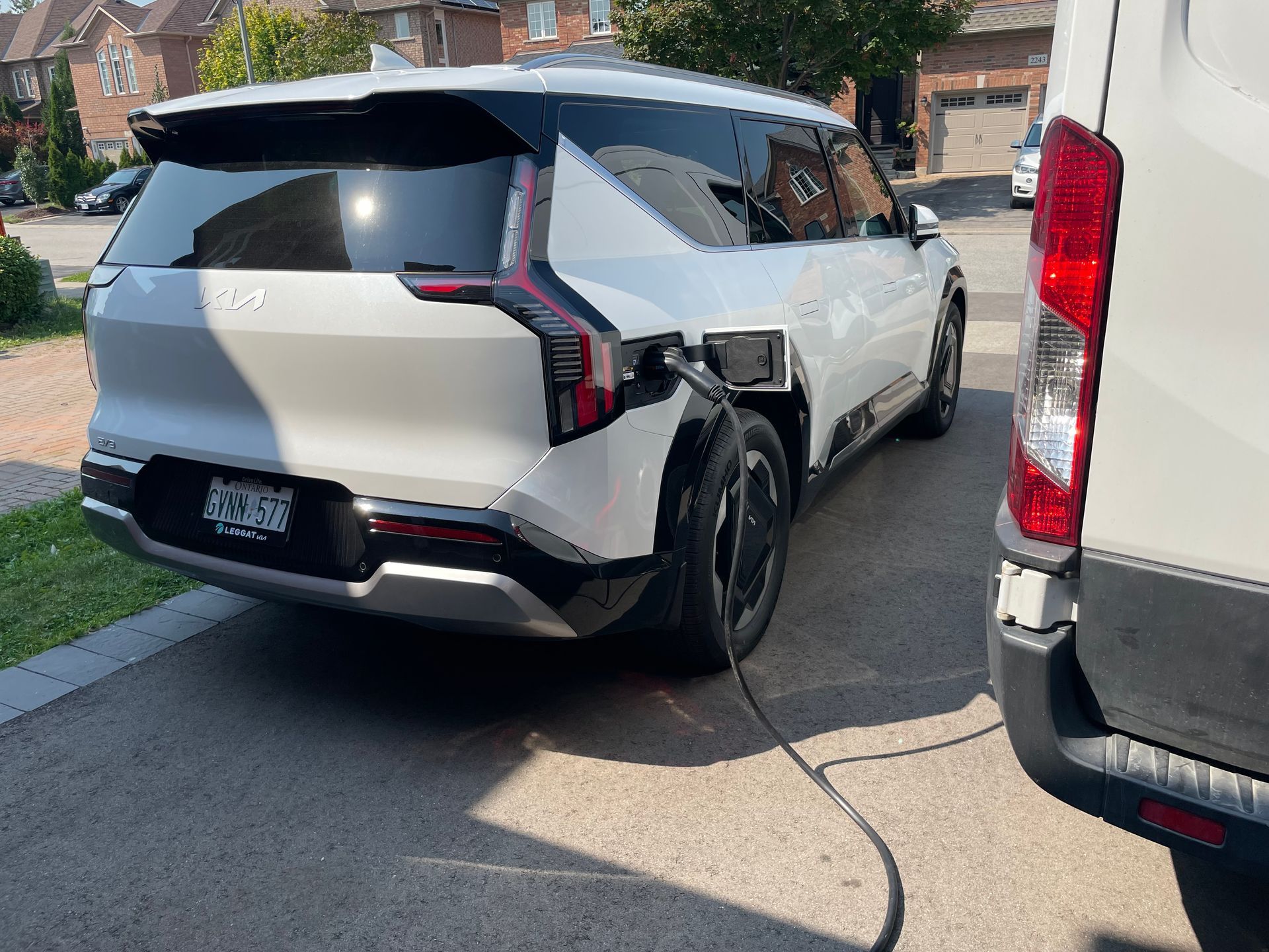 A white suv is being charged an ev charger